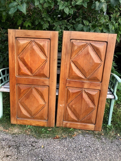 two pieces of wooden door in front of a bench