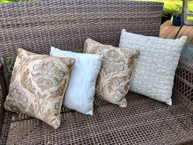 four throw pillows on a chair