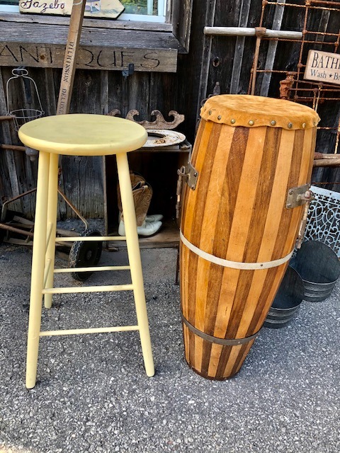 tall wooden chair next to a tall wooden drum