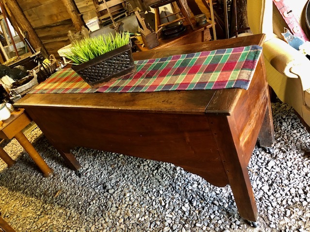 wooden table with checkered table cloth and plant on top