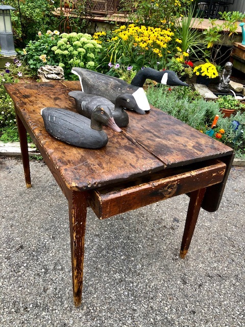 old wooden table with three duck figures on top