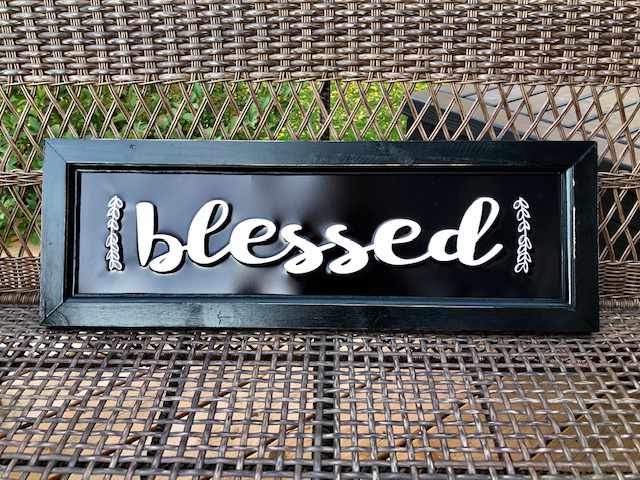 a sign in a wooden frame with the word blessed