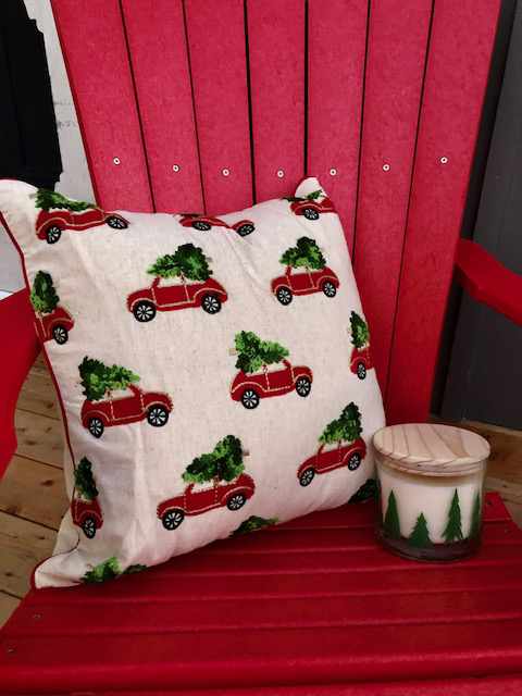 a red, wooden armchair with a festive cushion and a glass container with a wooden lid