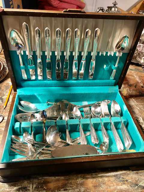a cutlery case holding embossed silver cutlery