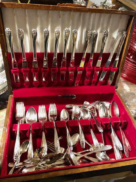 a cutlery case holding a variety of silver cutlery