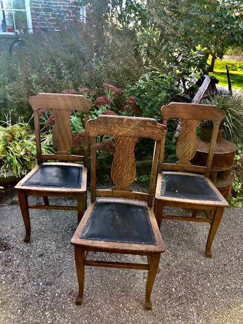 three wooden padded dining chairs