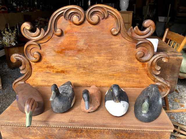 five duck statues on a wooden dresser