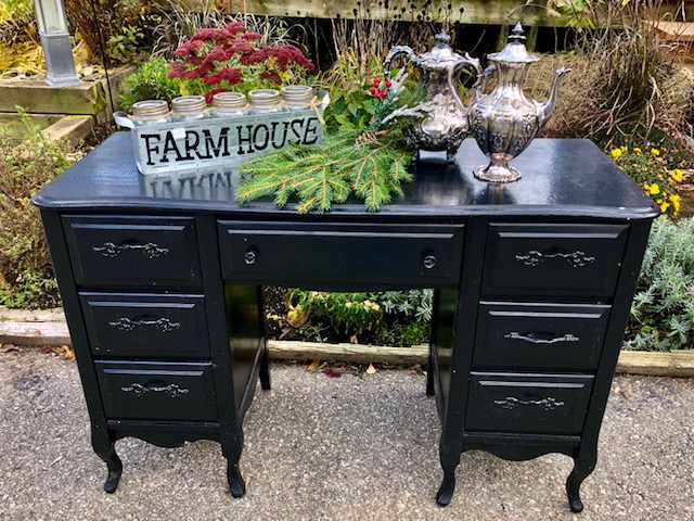 7 drawer wooden desk with bottling jars and silver teapots on top