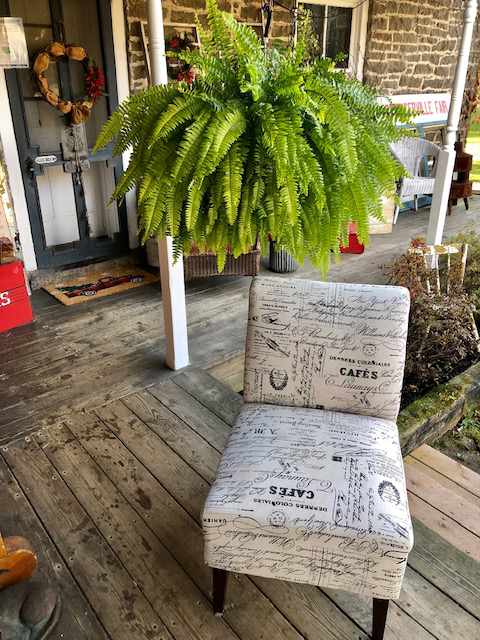 padded chair in cloth upholstery that looks like newspaper