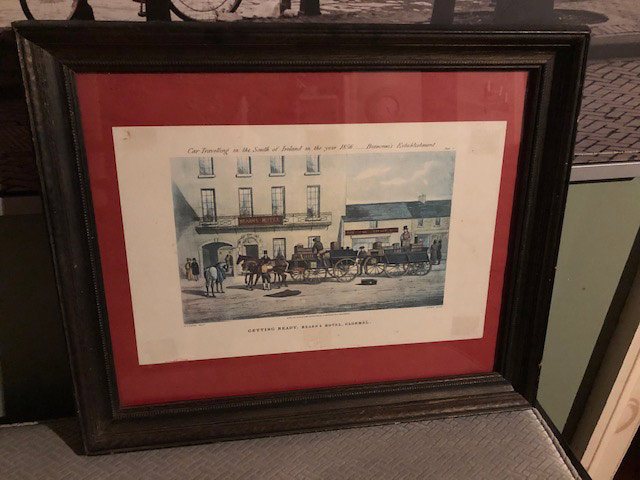 framed image of horses and carts in front of a building